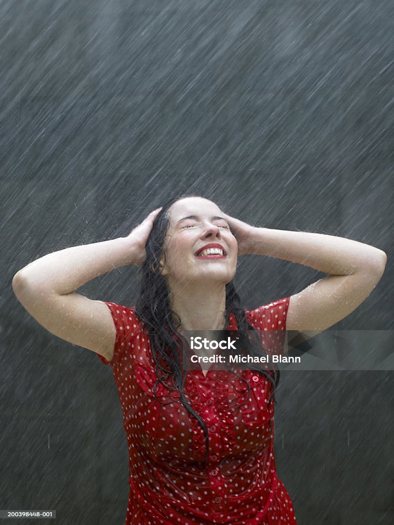 Młody Kaukaski Brunette kobieta Krzywa w deszczu, ręce na głowie - Zbiór zdjęć royalty-free (Deszcz)