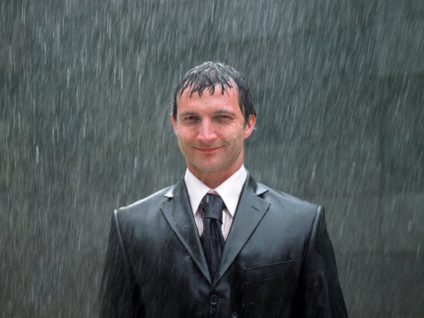 Hombre de negocios de pie en la lluvia, sonriendo, retrato, primer plano photo