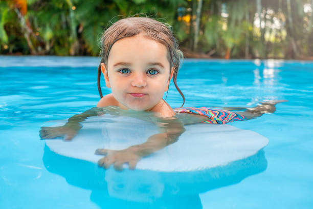 istock Child holding on a chair in the pool 2004010994