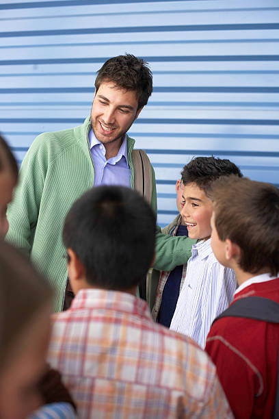 若い男性の学校の先生、お子様（8 -10 )、笑顔、クローズアップ - real people blue white friendship ストックフォトと画像