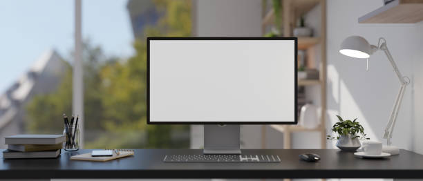 istock A modern home office features a computer mockup, a table lamp, and accessories on the table. 2004072790
