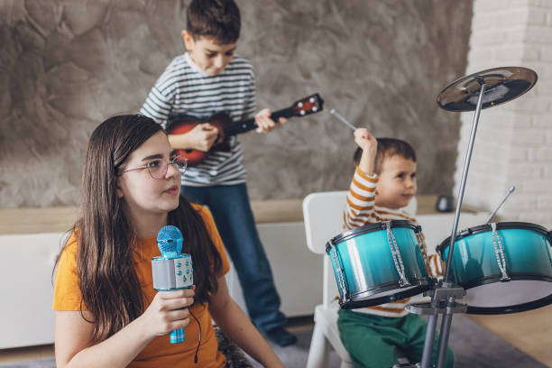 istock A Girl Singing Into A Microphone While Other Children Playing Instruments 2004093498