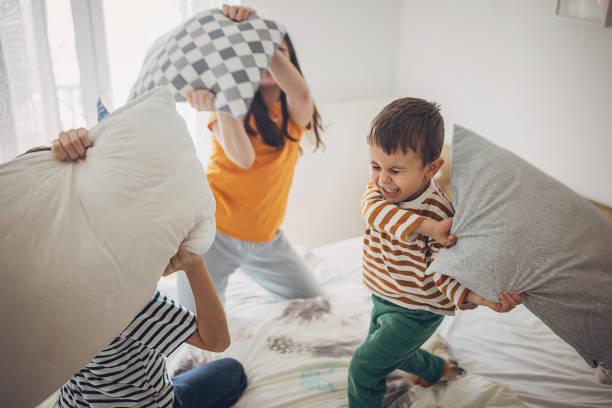 A Group Of Kids Fighting With Pillows