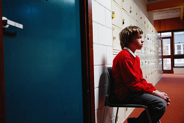 niño en edad escolar (11-13) sentado en silla de la zona, vista lateral - punishment fotografías e imágenes de stock