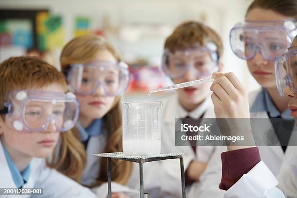 Pupils Wearing Goggles Watching Experiment In Science Class Stock Photo - Download Image Now