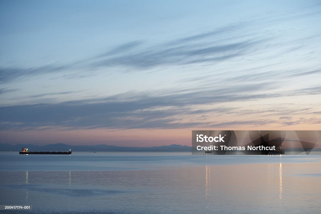 Canada, British Columbia, Vancouver, ships in English Bay at dusk view from Stanley Park, May 2006 Container Ship Stock Photo