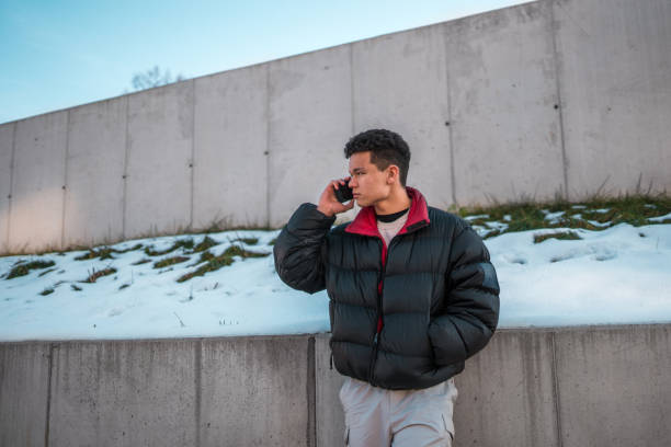 istock Asian Male Teenager Using Smartphone in Winter Setting 2004175796