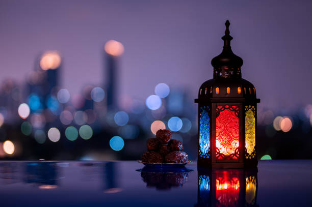 istock Lantern and small plate of dates fruit with night sky and city bokeh light background 2004197525
