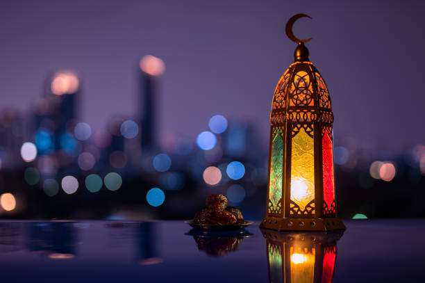 istock Lantern and small plate of dates fruit with night sky and city bokeh light background 2004197772