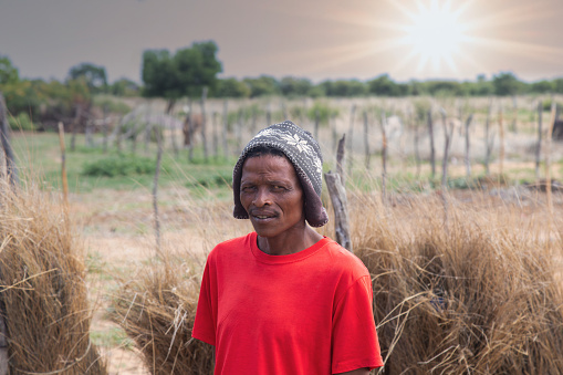village san african man, relocated from Kalahari to new villages, wearing a beanie,