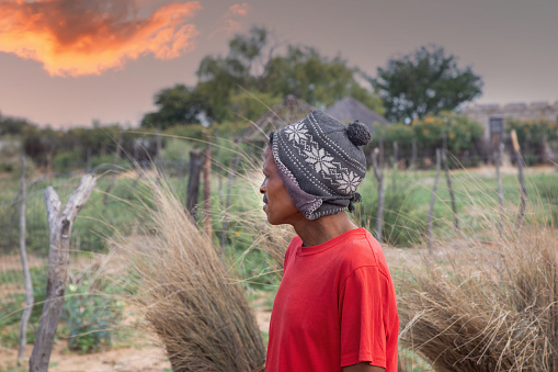 village san african man, relocated from Kalahari to new villages, wearing a beanie,