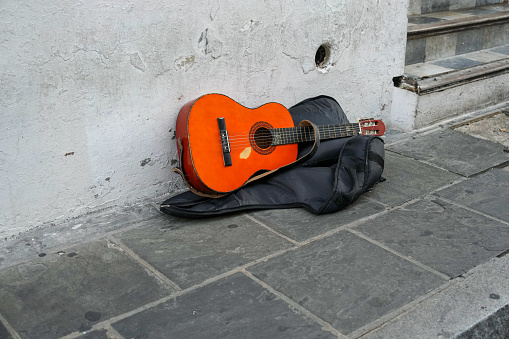 Worn wooden guitar of a street busker lying on the sidewalk of Old San Juan Puerto Rico