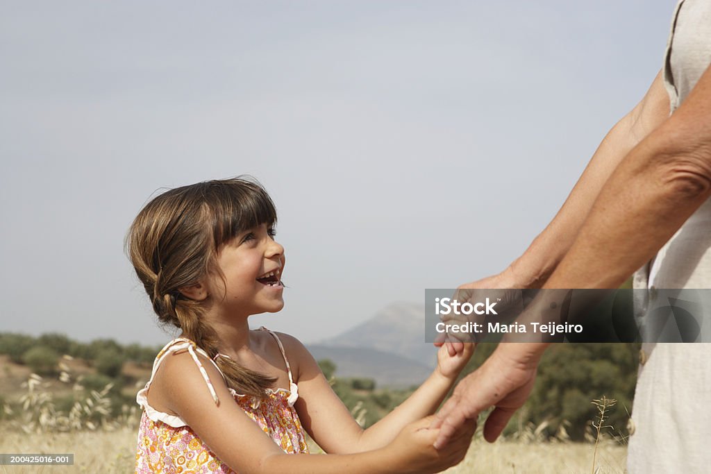 Girl (4-6) holding abuela manos, vista lateral close-up - Foto de stock de Nietos libre de derechos