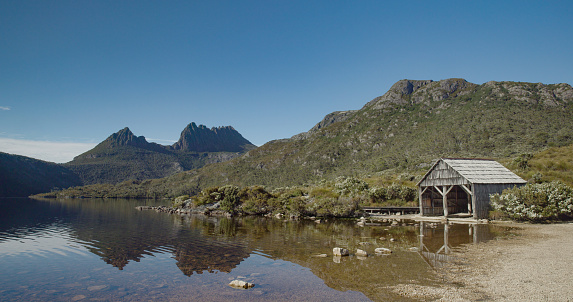 the old boat shed at dove lake with cradle mt in the distance on a calm summer morning at cradle mountain national park of tasmania, australia