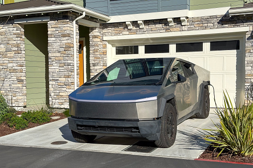 Tesla Cybertruck charging in driveway of residential house in Sunnyvale, California.