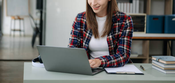 istock Confident woman with a smile standing holding notepad and tablet at the office. 2004271347