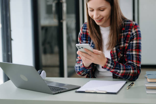 istock Confident woman with a smile standing holding notepad and tablet at the office. 2004271349