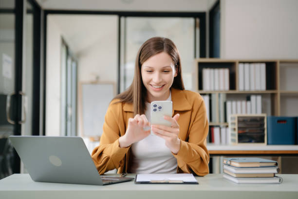 istock Confident woman with a smile standing holding notepad and tablet at the office. 2004271368