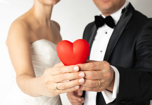 The bride and groom are holding heart.