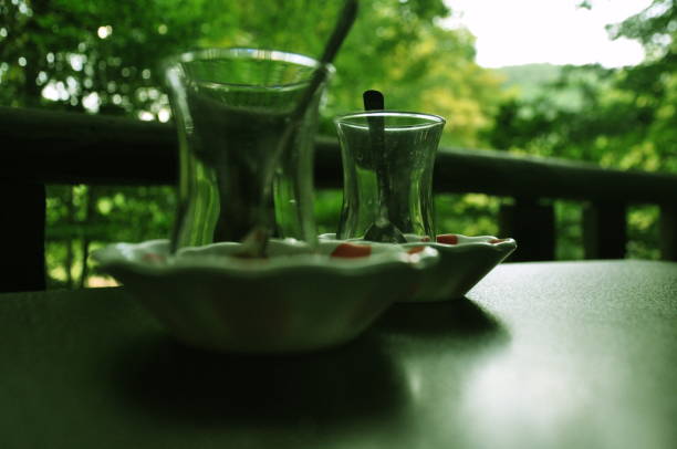 istock Two empty Turkish tea glasses on the wooden table and beautiful forest view. 2004316356