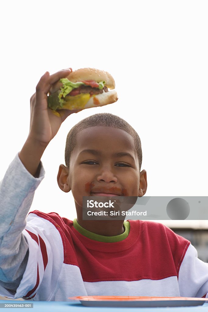 Ragazzo mangia hamburger (7-9) - Foto stock royalty-free di Piatto di carta