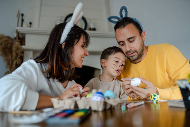 istock Young Family painting Easter eggs at home 2004359238