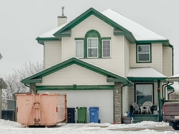 Calgary, Alberta, Canada. Feb 9, 2024. A detached or standalone family residence with a temporary rental dumpster situated in the front, indicating ongoing renovations during the winter season.