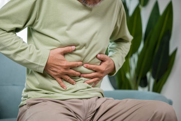 istock Elderly Asian old man sitting on sofa having stomachache 2004403797