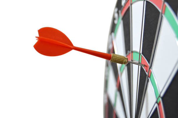 istock Cutout of one red dart or arrow off target on a dartboard isolated over horizontal white background denoting missing business target, or losing competition or match 2004405461