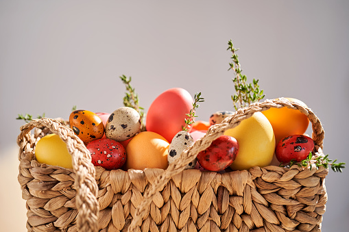 Easter colored eggs in a wicker bag. Easter composition. High quality photo