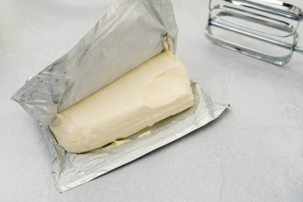 Unpucked brick of a cream cheese close-up on a kitchen table
