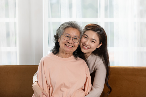 Heartfelt moment as a mid-age woman embraces her elderly mother with a warm and loving hug, celebrating the enduring bond between generations. Family Love Concept