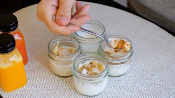 istock A person is spooning yogurt into a jar on a table 2004422016