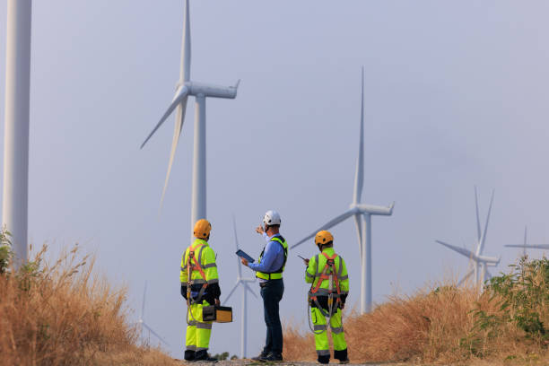 istock Engineer team hold equipment and tablet standing to talk planing project install wind turbines in the agricultural area. renewable energy installation project for the future world 2004441919