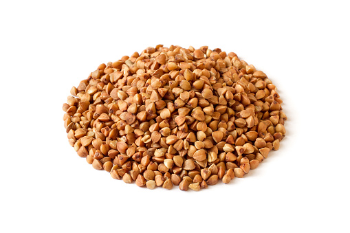 Pile of buckwheat groats isolated on white background. Buckwheat close-up.
