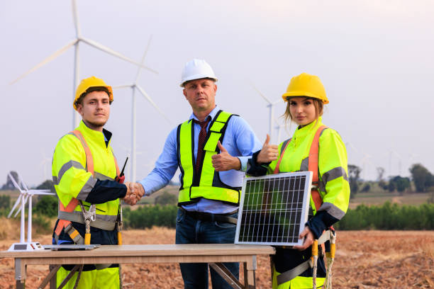 istock Engineer team standing shake hands in the meeting planing project install solar panel in the wind turbines farm. 2004454072