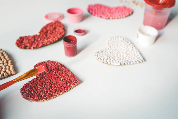Children's creativity from heart-shaped cereals top view, fine motor skills development concept.