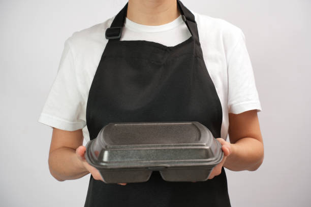 Chef holding lunch box with food in the hand, white background