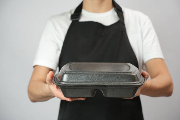 istock Chef holding lunch box with food in the hand, white background 2004466932