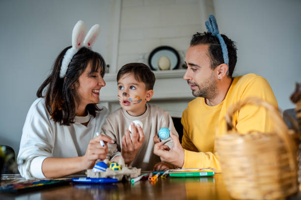 istock Young Family painting Easter eggs at home 2004472647