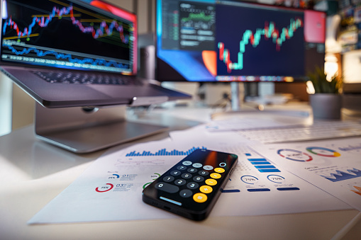 Currencies and finance. Stock exchange. Calculator on the table with documents and charts. Business analytics