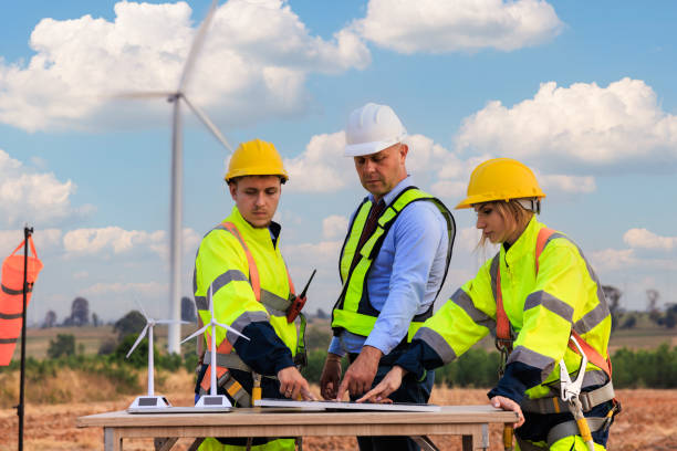 istock Engineer team standing to meeting planing project install solar panel in the wind turbines farm. 2004477395