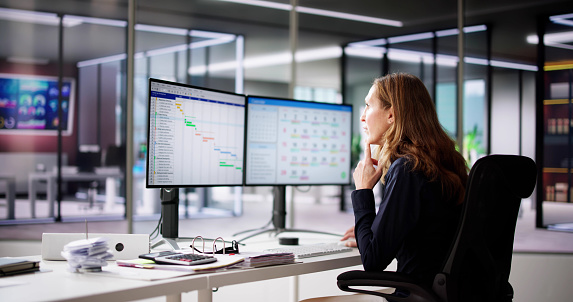 Employee Working On Calendar Schedule And Staff Time Sheet