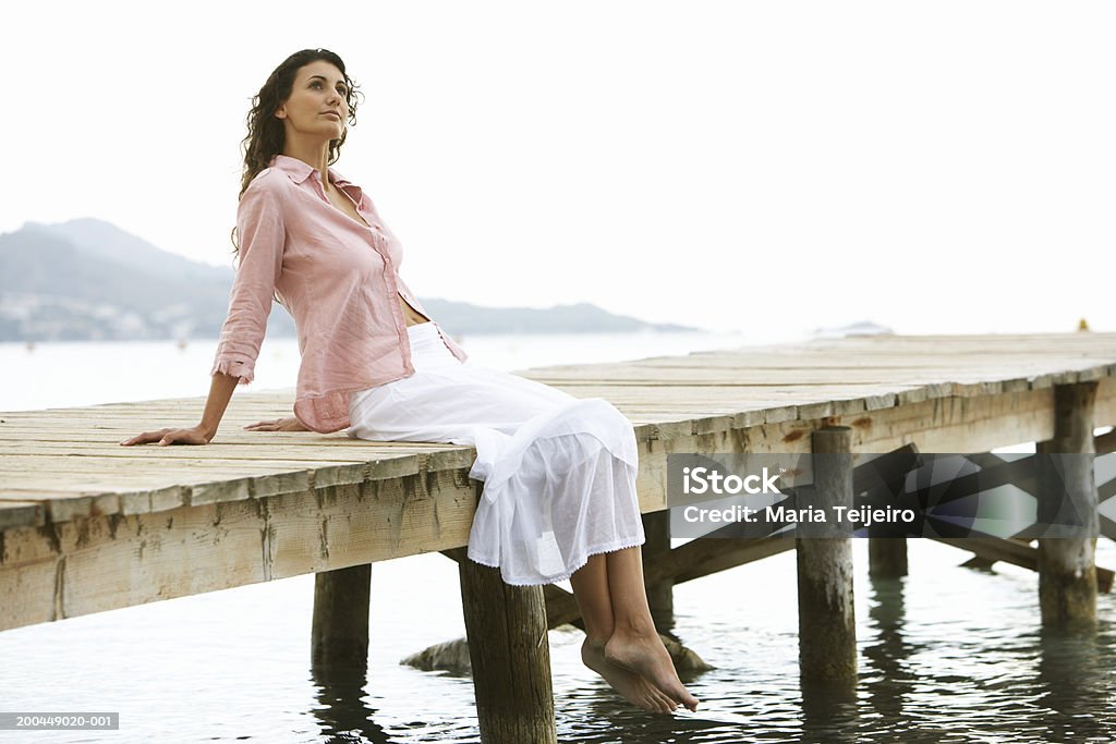 Young woman relaxing on jetty Majorca, Spain One Woman Only Stock Photo