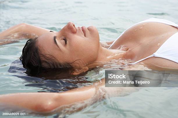 Young Woman Floating In Sea Eyes Closed Closeup Stock Photo - Download Image Now - One Woman Only, Bikini, Eyes Closed