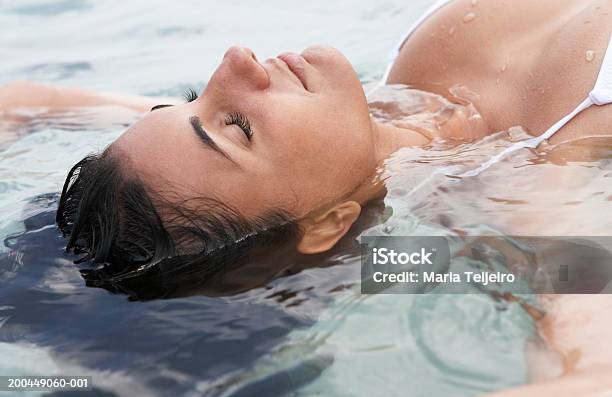 Photo libre de droit de Jeune Femme Flottant Sur La Mer Les Yeux Fermés Gros Plan banque d'images et plus d'images libres de droit de Une seule femme