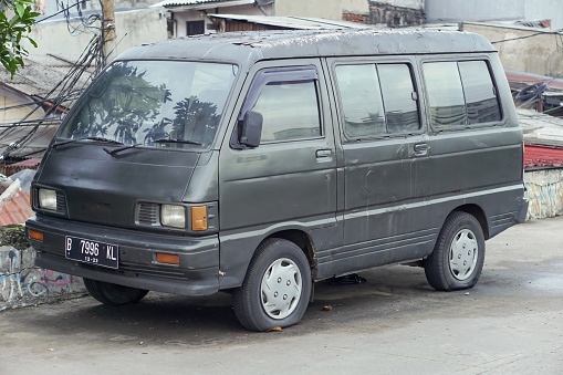 Jakarta, Indonesia - April 25, 2023: An old van on an embankment road in Jakarta.