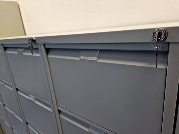 index card alphabetically arranged database of documents in metal pull-out drawers with a key lock. gray tin containers at the doctor's office