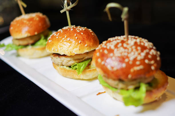 istock Mini burger sliders with ground chicken patty on white plate isolated black background 2004499214