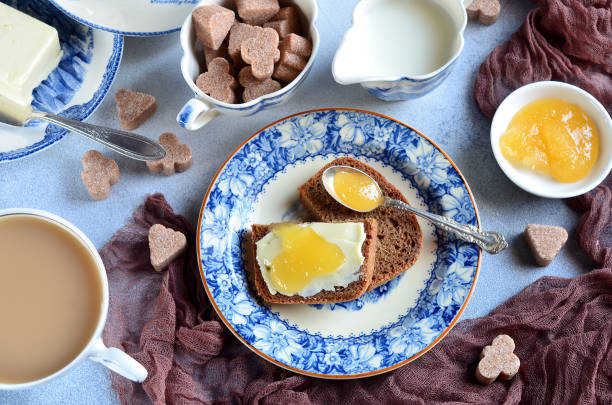 Breakfast serving - tea with milk, bread with butter and honey, close-up, top view, background, continental breakfast